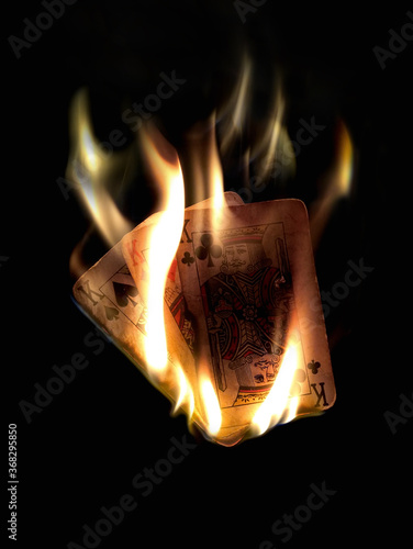 Burning trio of kings. Trio of king is a high hand in three card brag and the fire depicts it's power and superiority.
The cards were burned using gasoline and the shoot was done at night for Black .