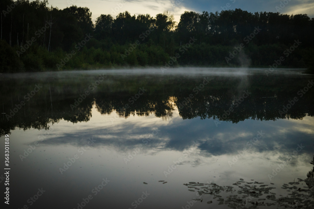 Fototapeta premium sunset over the lake in forest with fog