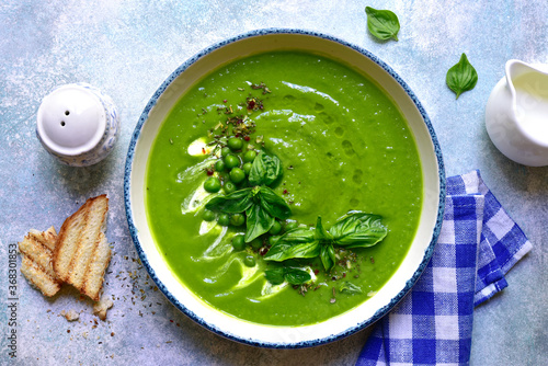 Pureed green pea soup with cream. Top view with copy space. photo