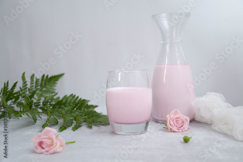pink  milk in the glass on the white background. © Di_Ilikaeva