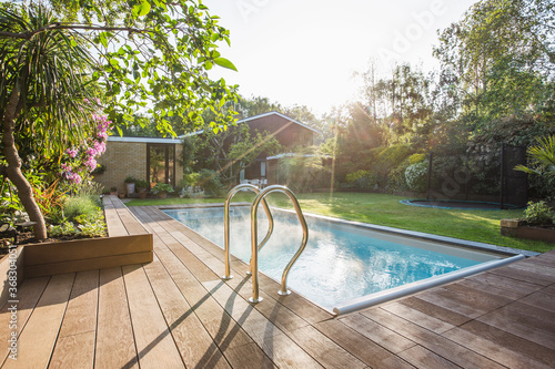 Sunny idyllic home showcase swimming pool and backyard photo