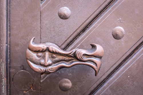 A whimsical doorknob on an exterior door in Europe.