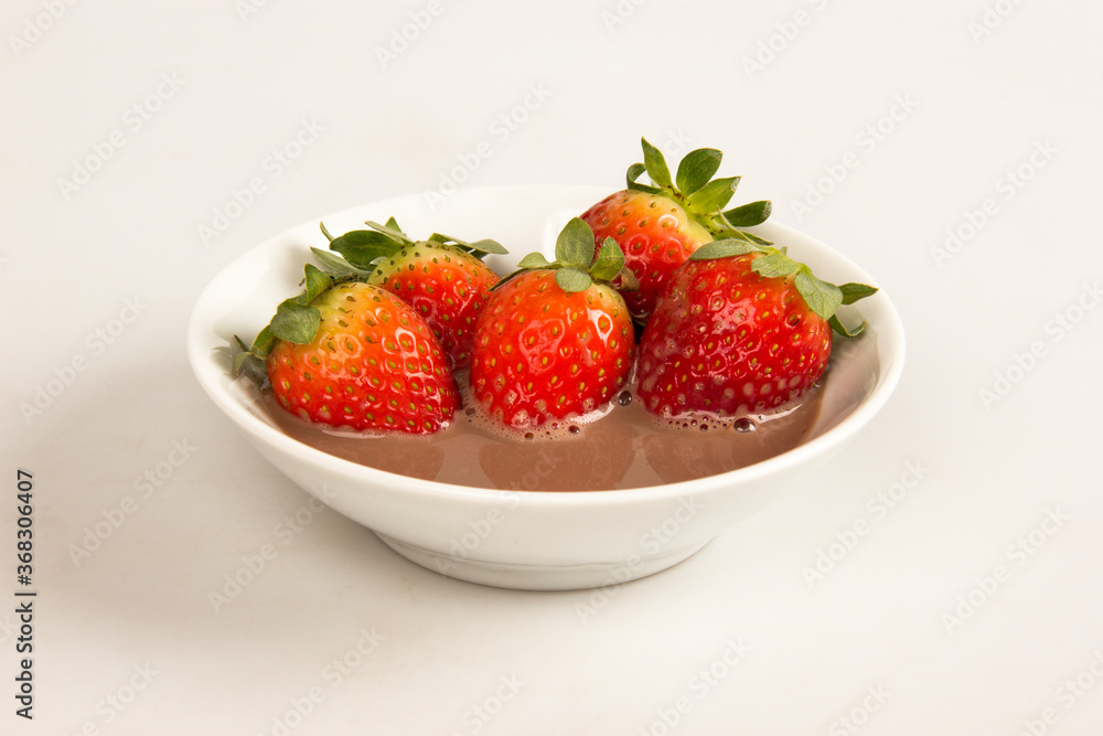 Fresh red strawberries in a bowl with chocolate cream. Fresh red strawberries in a bowl with chocolate cream.