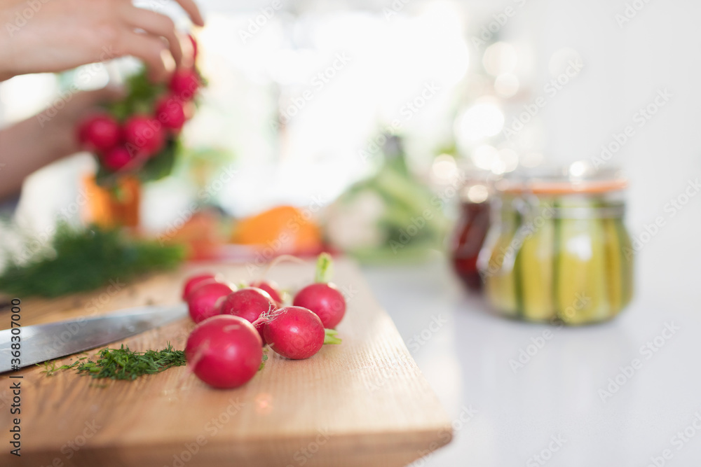 Woman preserving radishes in kitchen Woman preserving radishes in kitchen