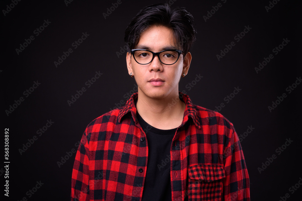 Fototapeta premium Young handsome Asian hipster man with eyeglasses