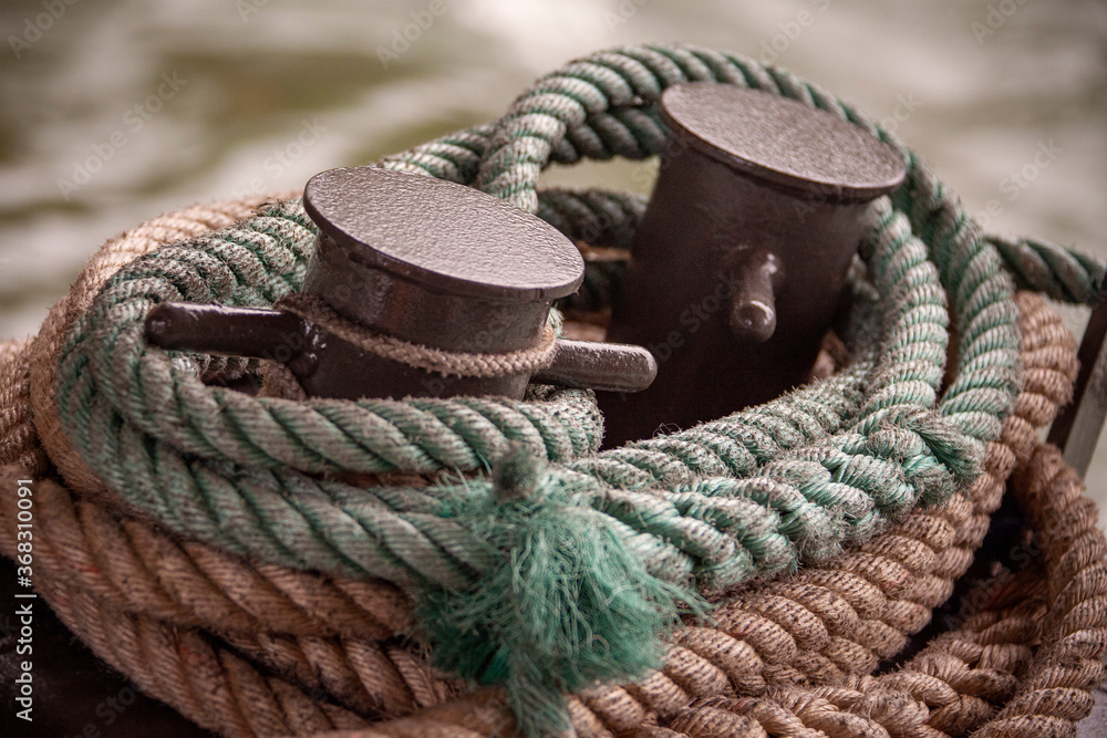 Thick colored ropes surround a nautical tie down.