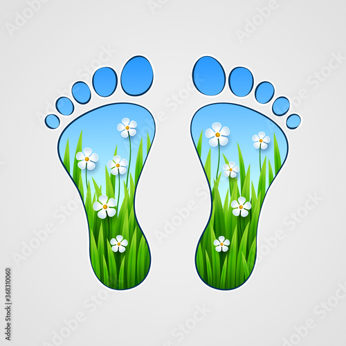 Silhouette of human footprints with grass and flowers inside