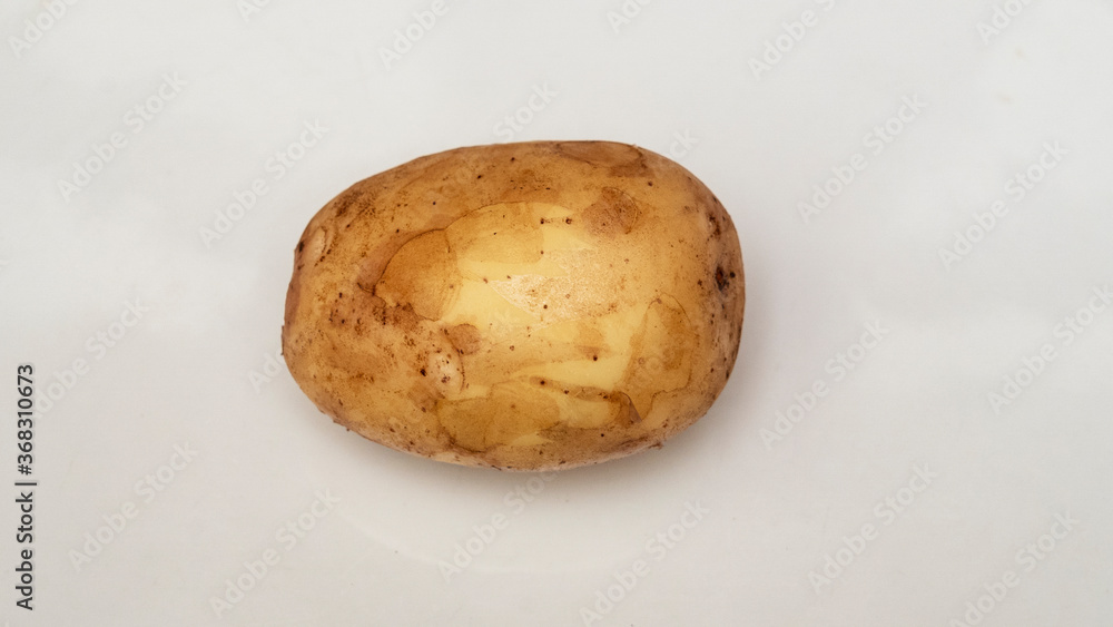 Fototapeta premium One tasty raw yellow potato isolated on white background. Health, food. The new harvest. Raw potato. Space for text.