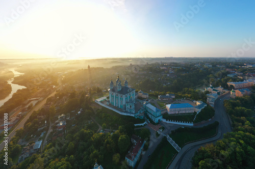 Aerial view of Uspenskiy Cathedral in Smolensk, Early summer morning and fog over the city in the rays of the rising sun. photo