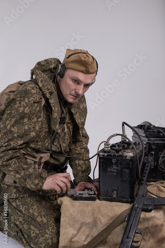 Male actor in the historical uniform of an officer of the Soviet Army with an intercom radio during World War II photo