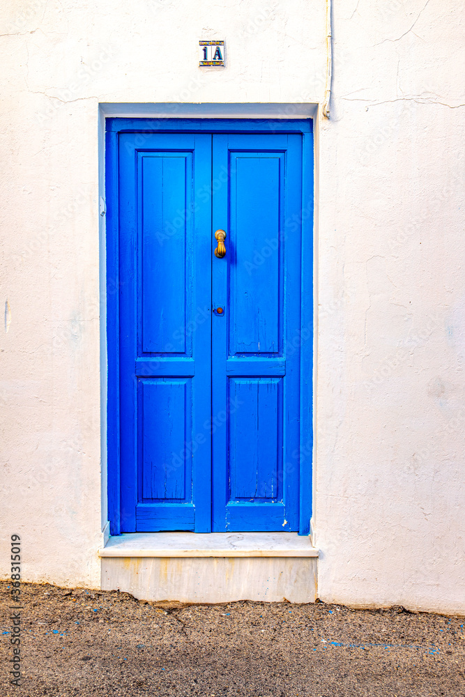 Puerta Azul con la pared blanca en barrio de Conil de Frontera