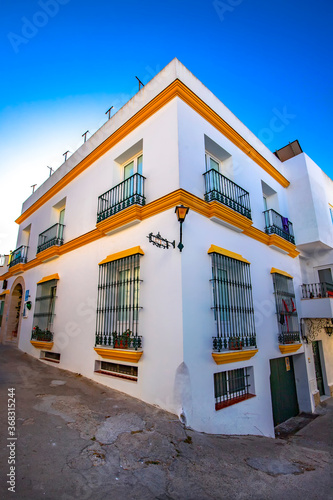 Edificio a dos calle con ventanas y balcones las tipicas calles de Conil de la Frontera