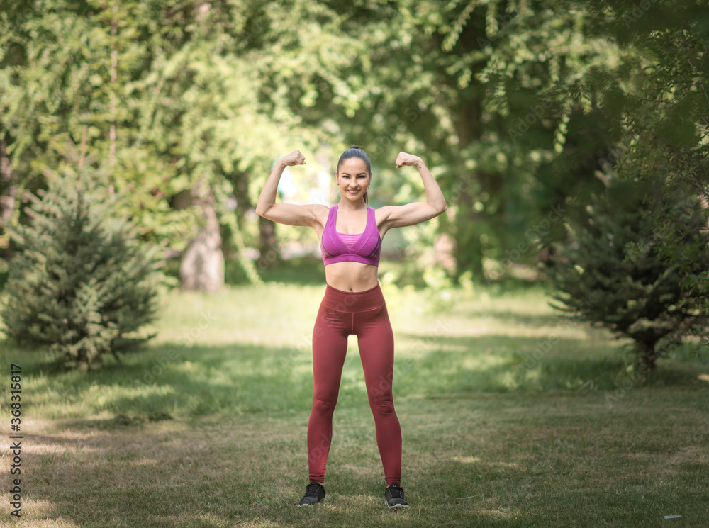 Woman doing sports exercises in the summer in the park. Healthy lifestyle.