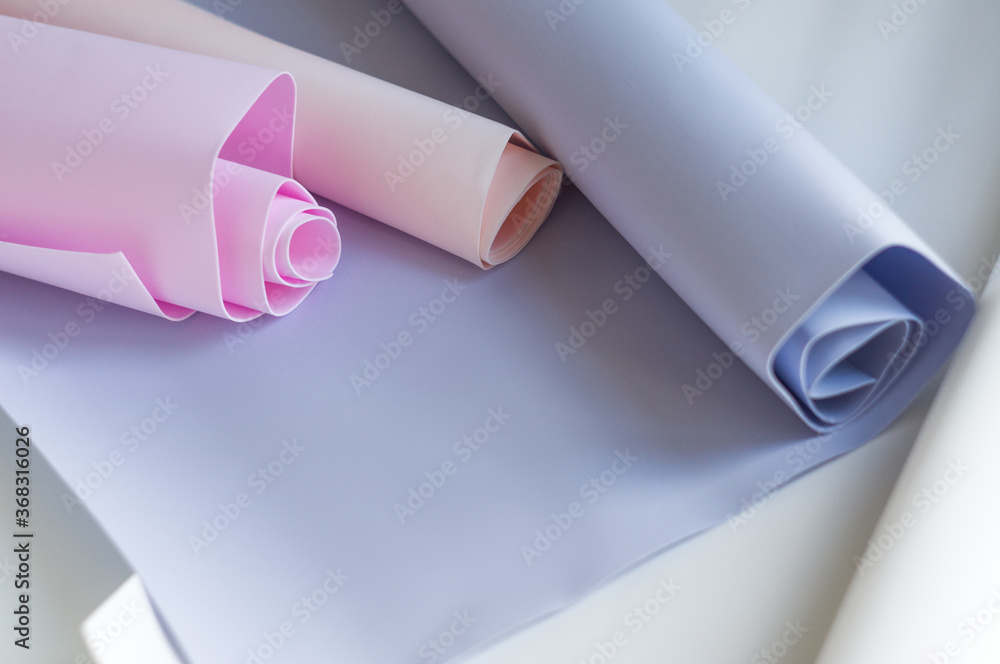 Colored hobby paper rolls in pastel shades. Pink and lilac rolled paper backgrounds. Horizontal photography. Colored hobby paper rolls in pastel shades. Pink and lilac rolled paper backgrounds. Horizontal photography.