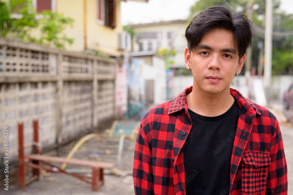 Young handsome Asian hipster man in the streets outdoors Young handsome Asian hipster man in the streets outdoors