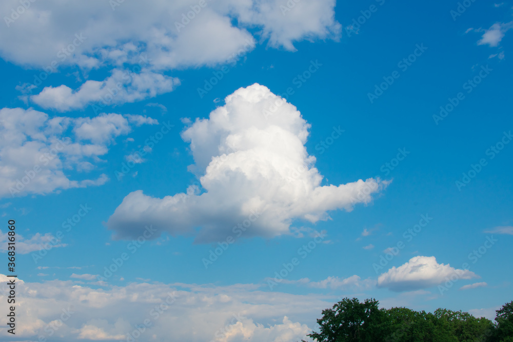 Large white orange cloud against the blue sky at sunset. Large white orange cloud against the blue sky at sunset.