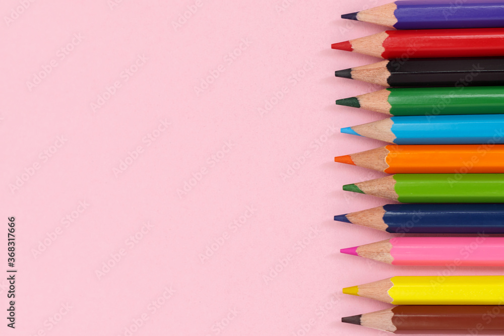 Multi-colored pencils on right side. Pink background. Banner on the site, copy space. Multi-colored pencils on right side. Pink background. Banner on the site, copy space.