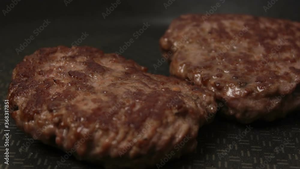 A chef puts beef patties on the grill. A juicy beef cutlet, fried in a pan. Close-up of beef cutlet for a burger on the grill. A chef puts beef patties on the grill. A juicy beef cutlet, fried in a pan. Close-up of beef cutlet for a burger on the grill.