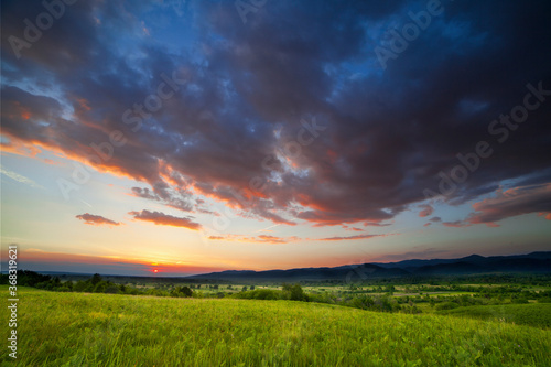 Dramatic sunset over green field