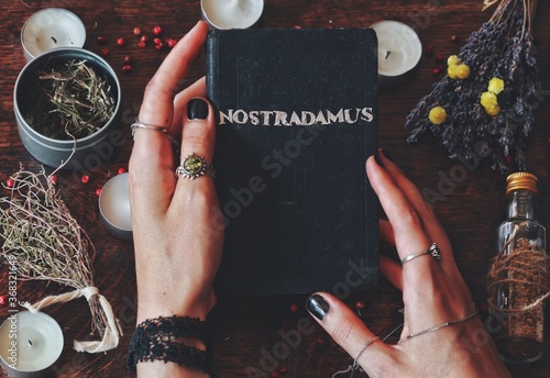 Wiccan witch holding a small diy hand made book in her hands that has a word 