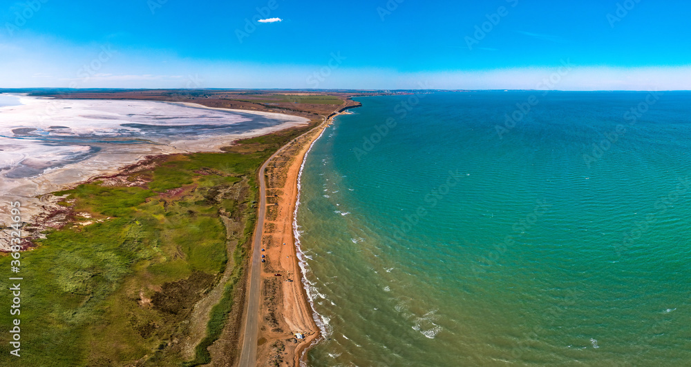 separated from the Black Sea by a sandy spit Tobechikskoe salt lake (estuary) in the south of the Kerch Peninsula (Crimea, southern Russia) aerial panorama on a sunny summer day