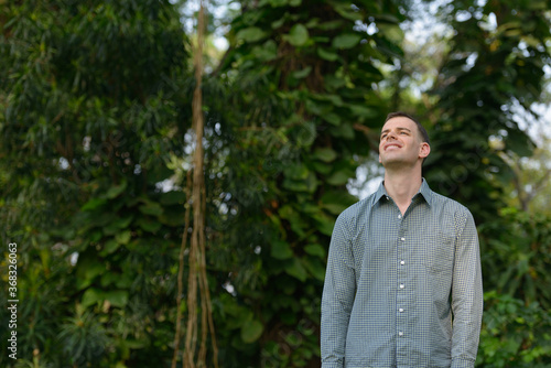 Portrait of happy businessman relaxing at the park