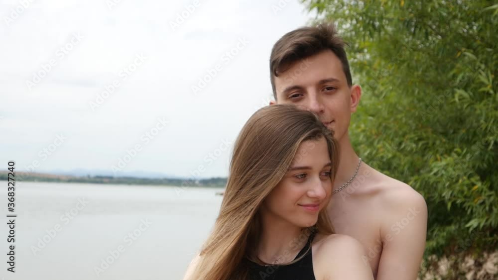 Young Man and Woman embracing on a Beach at happy summer Day Young Man and Woman embracing on a Beach at happy summer Day