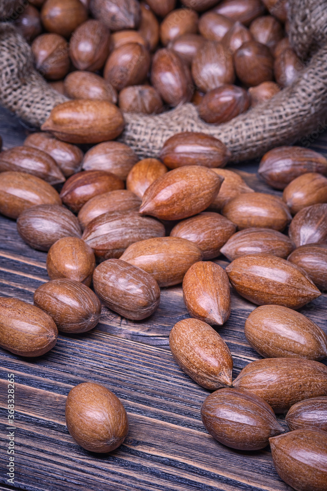 Pecannuts in bag, vegetarian food in wooden bowls, on old wooden background Pecannuts in bag, vegetarian food in wooden bowls, on old wooden background