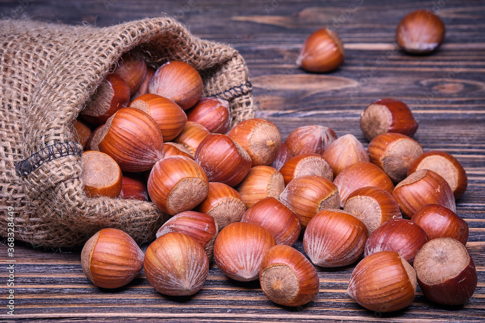 Hazelnuts in bag, vegetarian food in wooden bowls, on old wooden background Hazelnuts in bag, vegetarian food in wooden bowls, on old wooden background