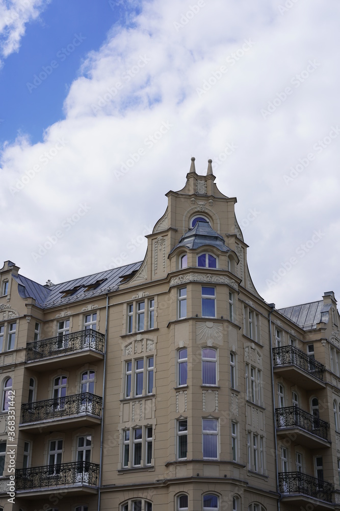 Sehenswertes, großes Jugendstilhaus in Poznan unter blauem Himmel und weißer Wolke bei Sonnenschein Sehenswertes, großes Jugendstilhaus in Poznan unter blauem Himmel und weißer Wolke bei Sonnenschein
