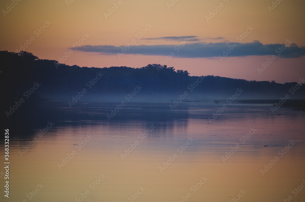 Obraz premium Evening twilight over a foggy lake.