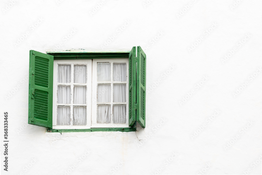 A green open window in a white house in the old medina of the historic city of Asilah in Morocco