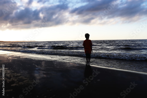 boy walking on the beach - longing