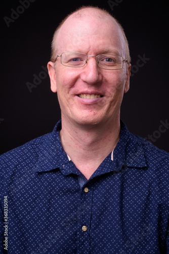 Portrait of happy bald businessman with eyeglasses