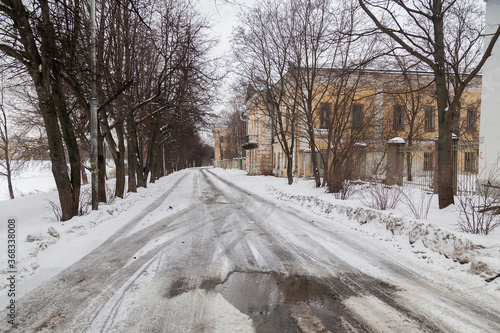 Snowy spring road in russian villiage