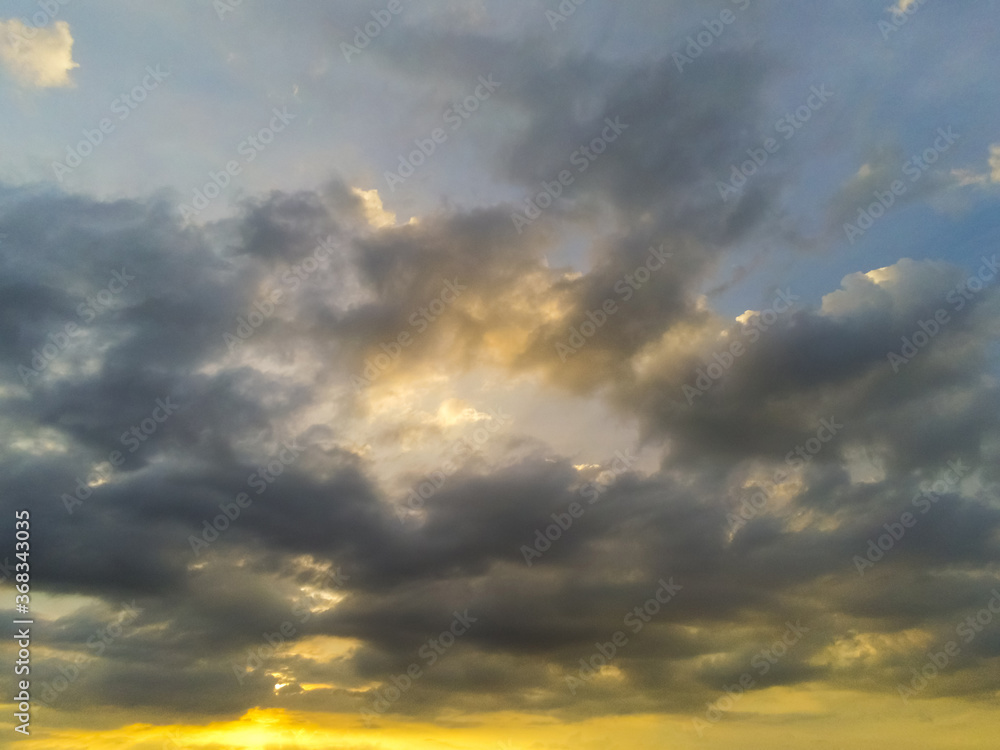 Beautiful cloudy sunset sky with blue and yellow tones.