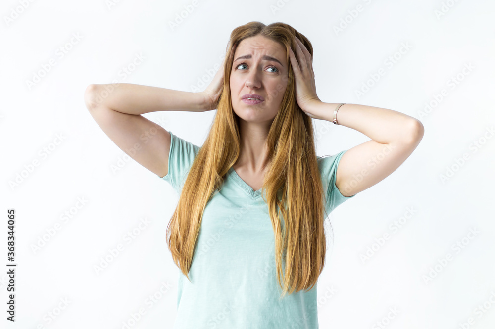 Girl with an expression of fatigue, hands holding her head, look up. Photo on white background