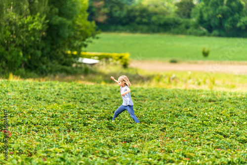 Little girl running in strawberry field in Sevenoaks, Kent