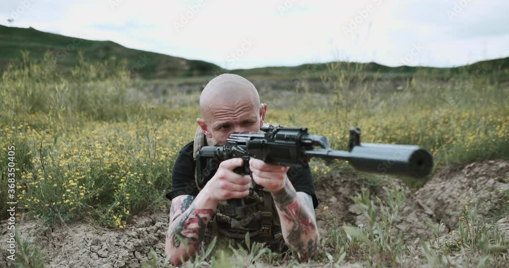 Man in black suite soldier aims automatic gun onto camera prepared to shot. Winter autumn forest. 4k slow motion Concept of war, thriler, pursuit. Man in black suite soldier aims automatic gun onto camera prepared to shot. Winter autumn forest. 4k slow motion Concept of war, thriler, pursuit.