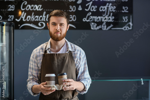 Young male barista holding ...