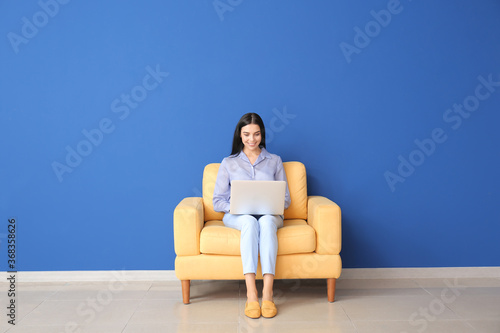 Young woman with laptop rel...