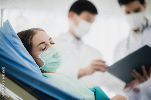 young woman patient receiving oxygen mask lying on a hospital bed, concept of medical and patient