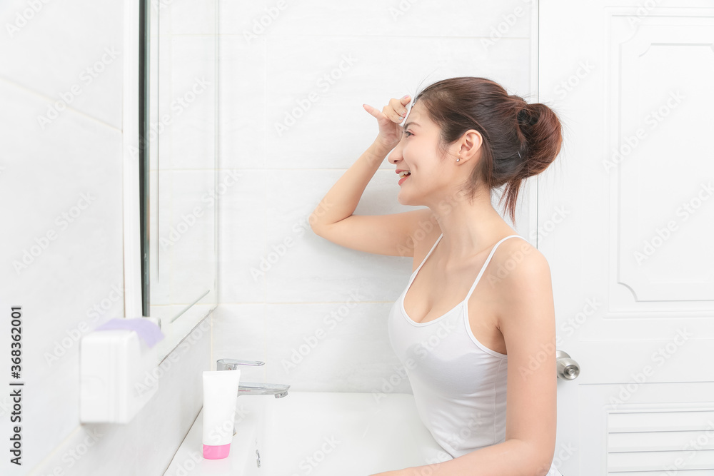 Beautiful Asian Woman applying cosmetic cream reflection in the mirror. Beautiful Asian Woman applying cosmetic cream reflection in the mirror.