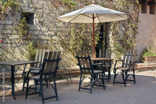 A parasol unmbrella at a beautiful garden with their chairs. A sunny day in the spring with the friends