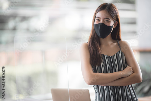 Asian business woman freelancer wearing surgical face mask, social distancing of the new normal lifestyle after epidemic of coronavirus COVID-19