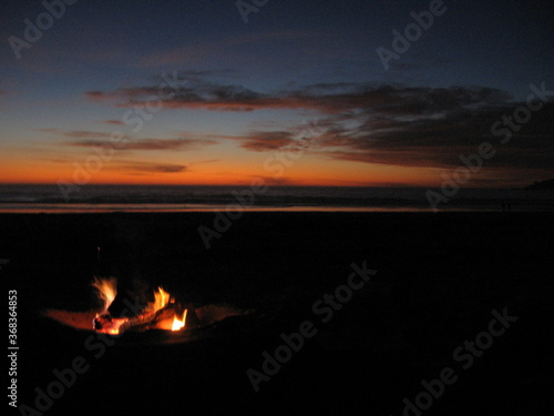 Beach bonfire burning at sunset