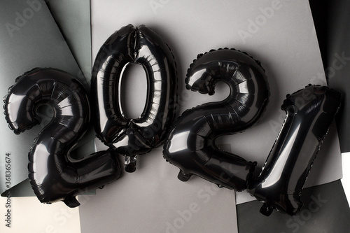 Christmas New Year 2021 numbers Stylish silver black Air balloons on gray. Celebration, seasonal holiday creative abstract background, flat lay, banner for site, party decoration photo