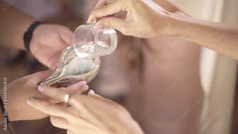 Holy water poured in conch shells in a Thai wedding ceremony Holy water poured in conch shells in a Thai wedding ceremony
