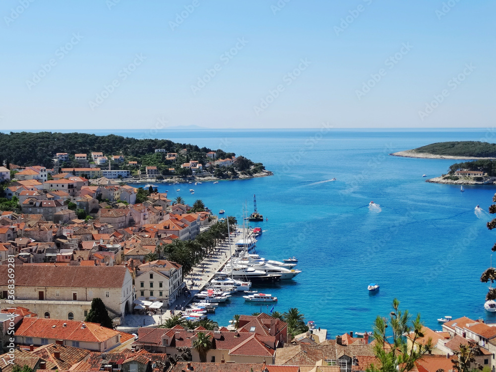 Yachts stop in Hvar harbor in Croatia. Panoramic view of cityscape and landscape of Hvar island in Croatia.