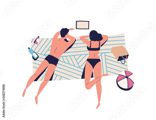 Relaxing people, sunbathing couple on beach blanket. Woman, man watching movi...